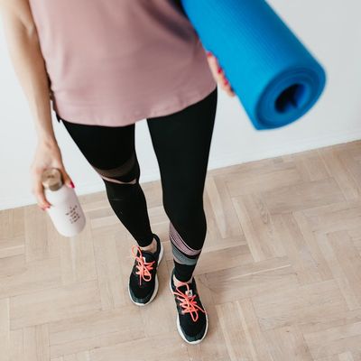 A bottle of water next to a rolled-up exercise mat.